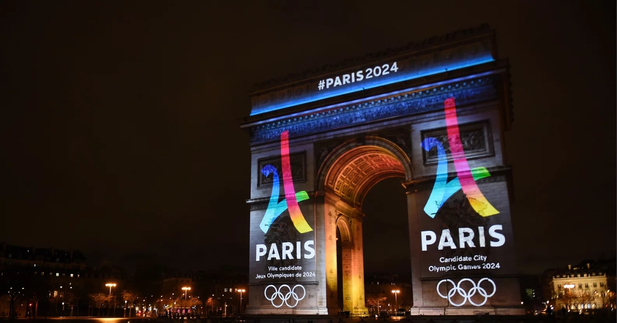 Arc de Triomphe lit up with the words Paris 2024 and the Olympic Symbol