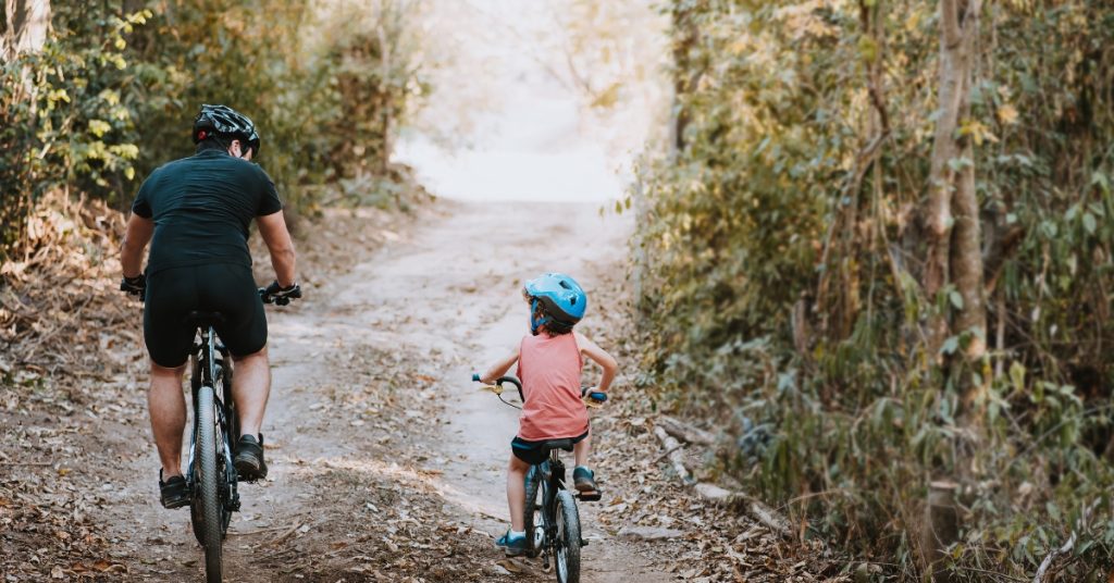 Father and son cycling in the countryside off road