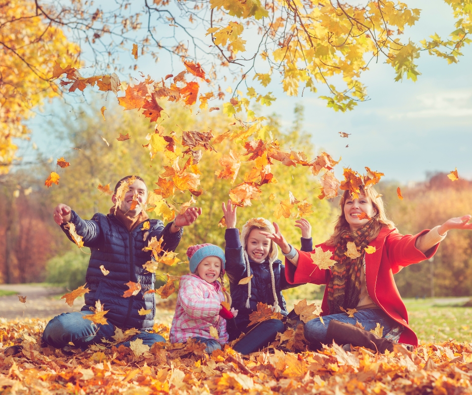 Family having fun in autumn leaves