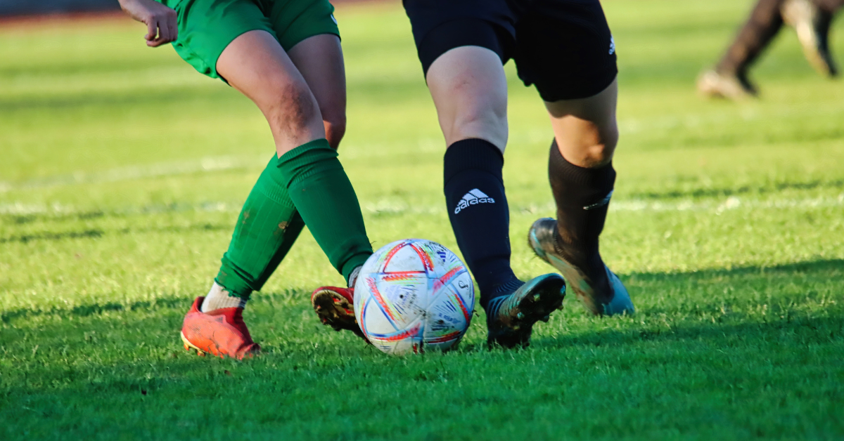 Footballer legs and soccer ball